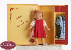 Foto muñeca Leonor, con traje rojo que incluye armario con un vestido azul.