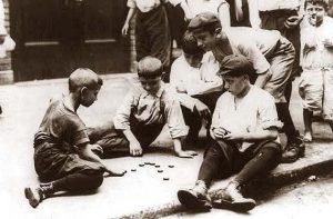 Jugar en grupo. Foto de varios niños jugando a las chapas
