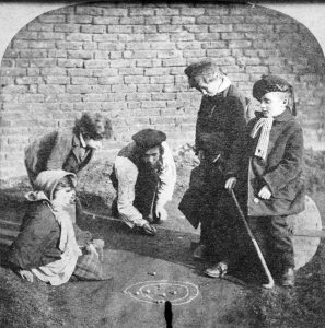 Jugar en grupo. Foto de varios niños jugando con las canicas