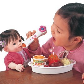 Foto niña aprendiendo a jugar con muñecas y comida