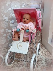 Foto de bebé reborn con una sillita big rosa de Bebelux