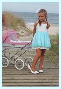 Foto de una modelo infantil con un cochecito rosa de Bebelux