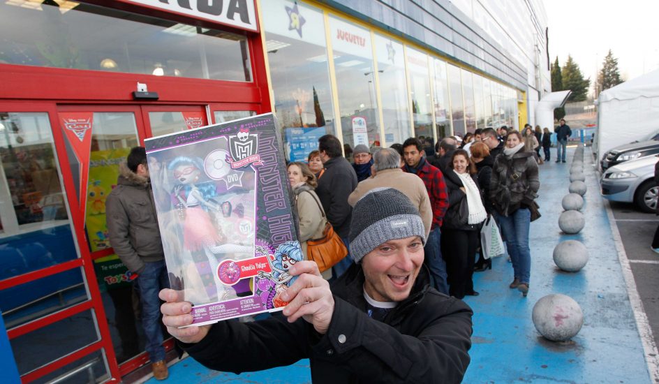 Foto de un padre en la entrada de una tienda con una de las muñecas Monster High